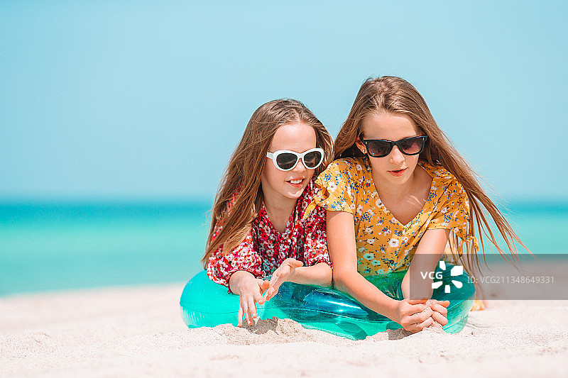 两个快乐的小女孩在热带海滩玩得很开心图片素材