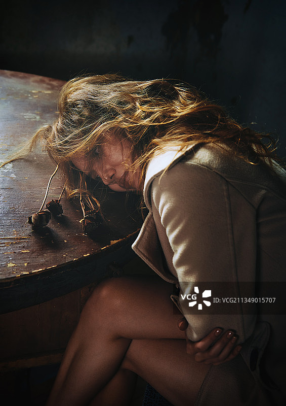 一个忧郁的女人躺在桌子上图片素材