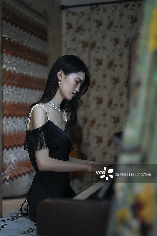 室内穿着黑色连衣裙弹钢琴的女孩图片素材