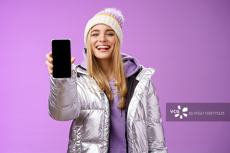 微笑的女人肖像使用手机在粉红色的背景图片素材
