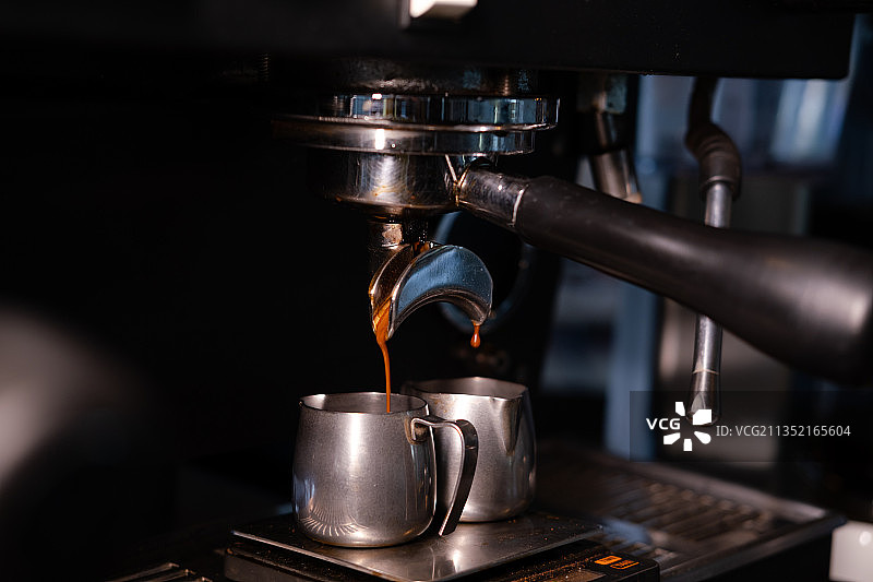 特写咖啡倒在咖啡机的咖啡杯在咖啡馆图片素材