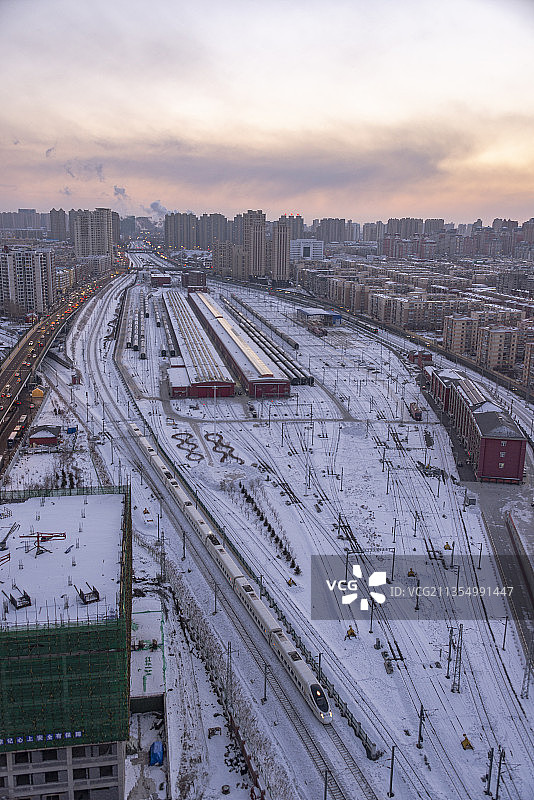 冬日黄昏暮色时分，动车组列车接近哈尔滨站图片素材