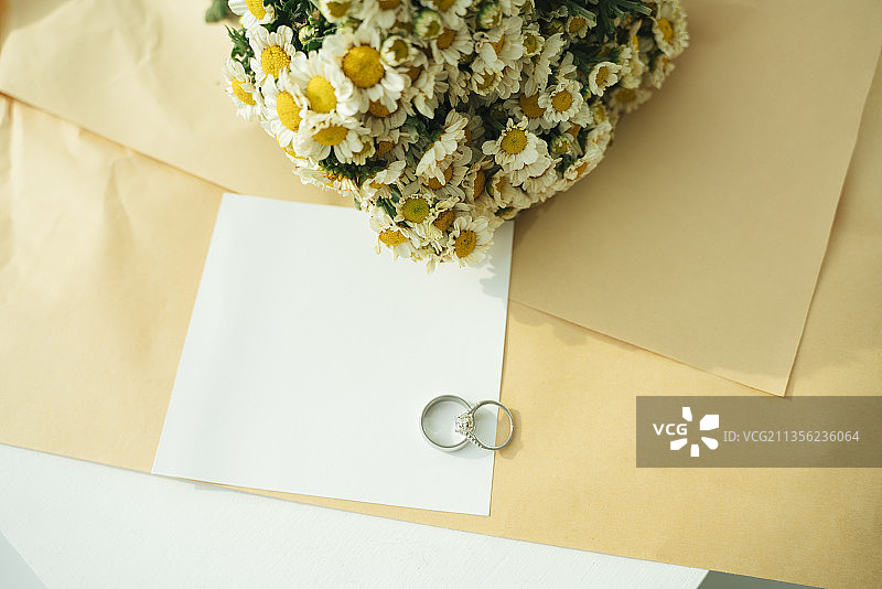 用银戒指、纸和花装饰婚礼用纸。副本的空间。图片素材