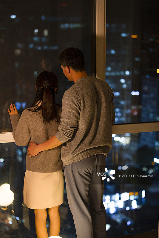 甜蜜情侣站在客厅窗户前看夜景图片素材