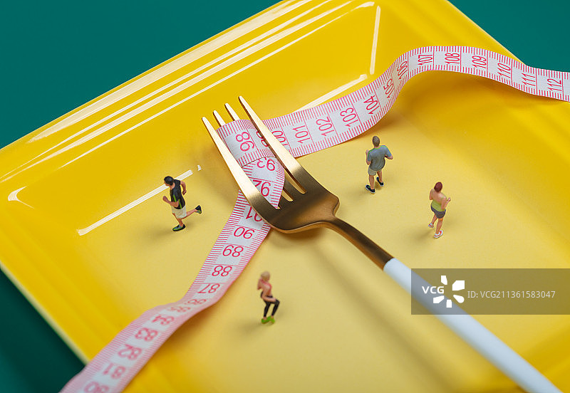 微缩创意餐盘里的叉子卷尺与慢跑健身的人群图片素材