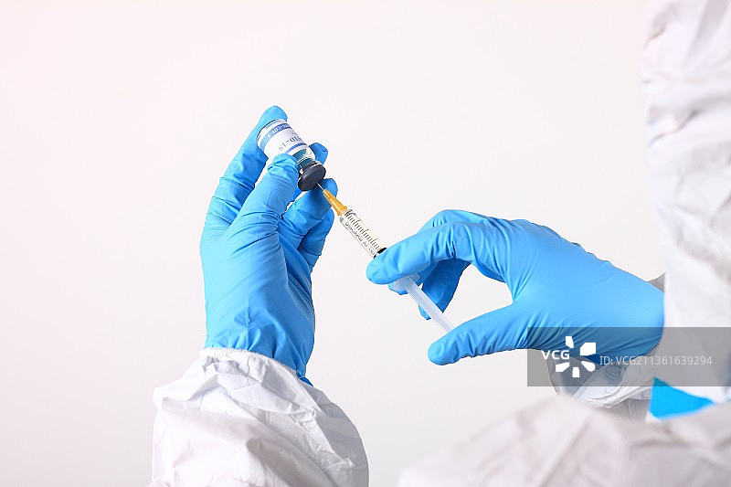 身穿防护服的医生手拿新冠疫苗注射器图片素材