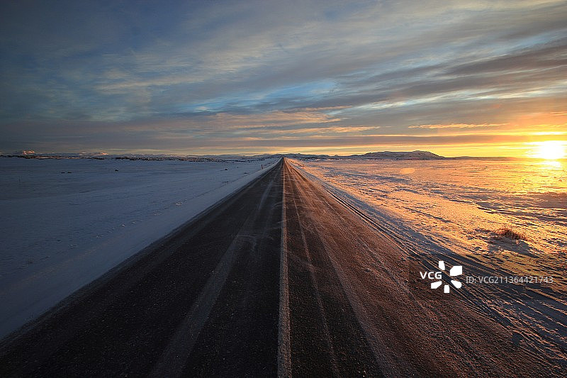 金色的冰岛，日落时天空映衬下的空旷道路图片素材