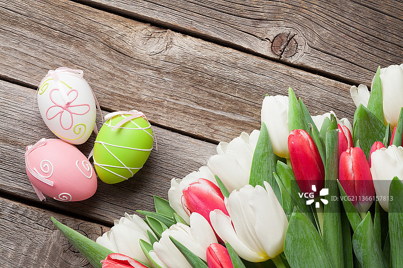 复活节彩蛋和郁金香花束，从高角度观看五彩缤纷的复活节彩蛋放在桌上图片素材