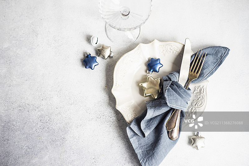 白色混凝土桌子上的圣诞晚餐的简约餐桌设置图片素材