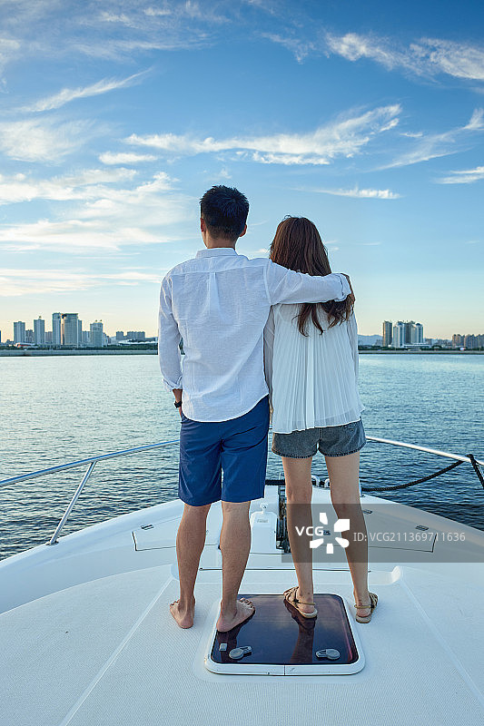浪漫的青年夫妇乘坐游艇出海图片素材