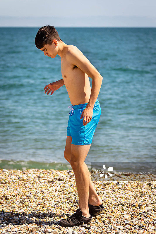 在英国西苏塞克斯的岩石海滩附近，一名赤裸上身的男士正在锻炼身体图片素材