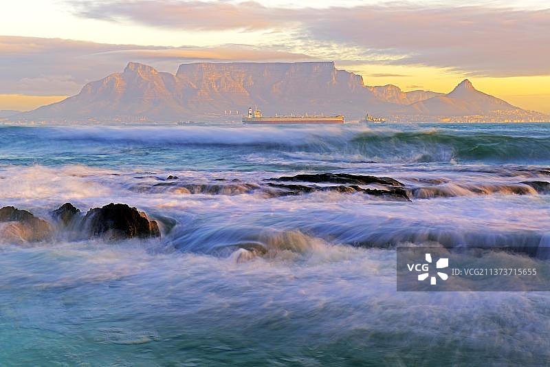 从南非西开普省开普敦的Bloubergstrand海滩上看到的黄昏的桌山图片素材