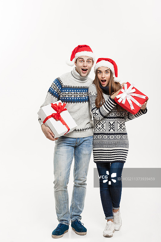圣诞概念-年轻可爱的夫妇拿着礼物孤立图片素材