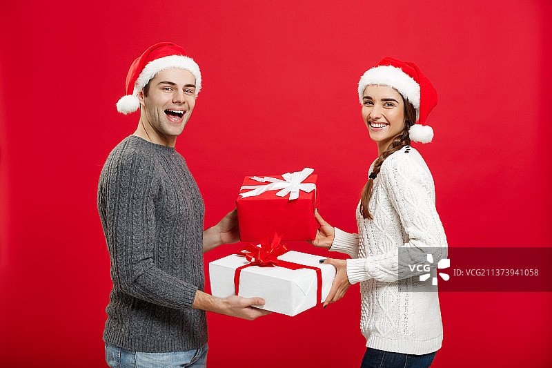 圣诞概念——年轻迷人的情侣互赠礼物图片素材
