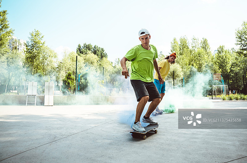 滑板公园里带着彩色烟雾弹的溜冰者图片素材