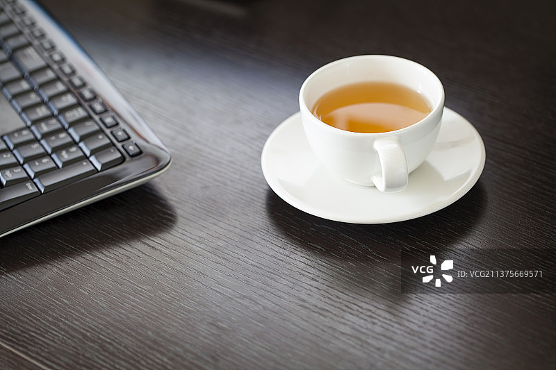 桌面上一杯茶和键盘图片素材