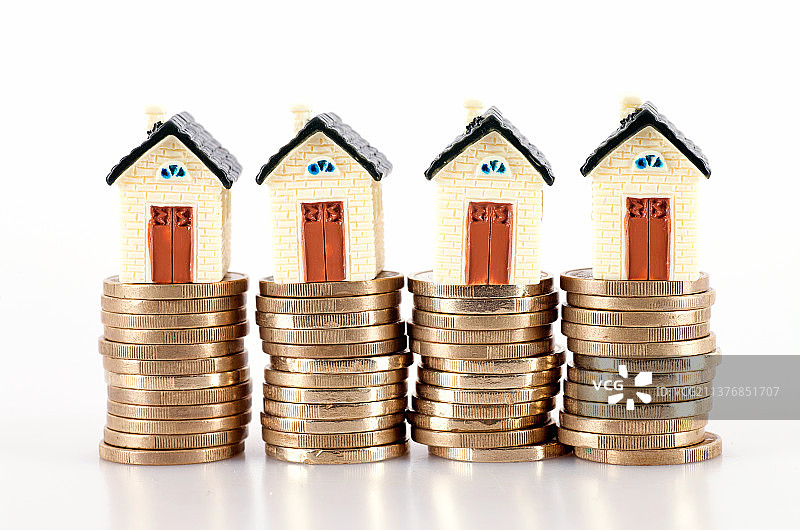 白背景上一排欧元硬币和上面的小房子模型图片素材