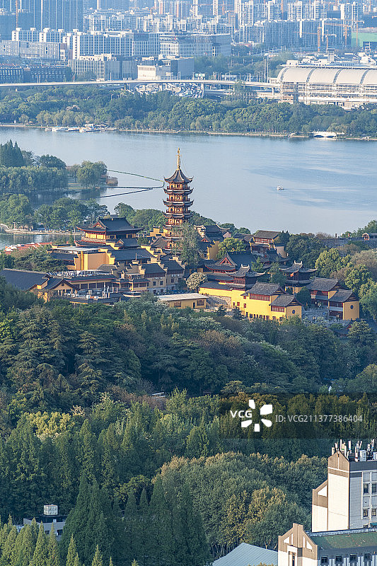 远眺南京玄武湖畔包围在郁郁葱葱树林中的鸡鸣寺图片素材