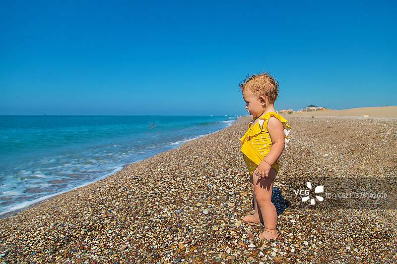 宝宝正坐在海边的沙滩上选择性的集中注意力图片素材