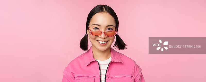 时尚的韩国女孩在太阳镜的特写，微笑快乐，摆姿势图片素材