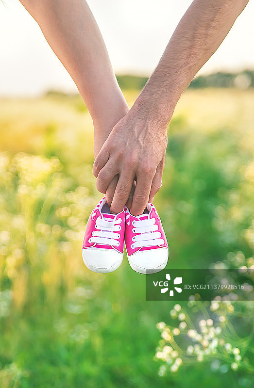 孕妇和男人持有婴儿鞋选择性聚焦自然图片素材