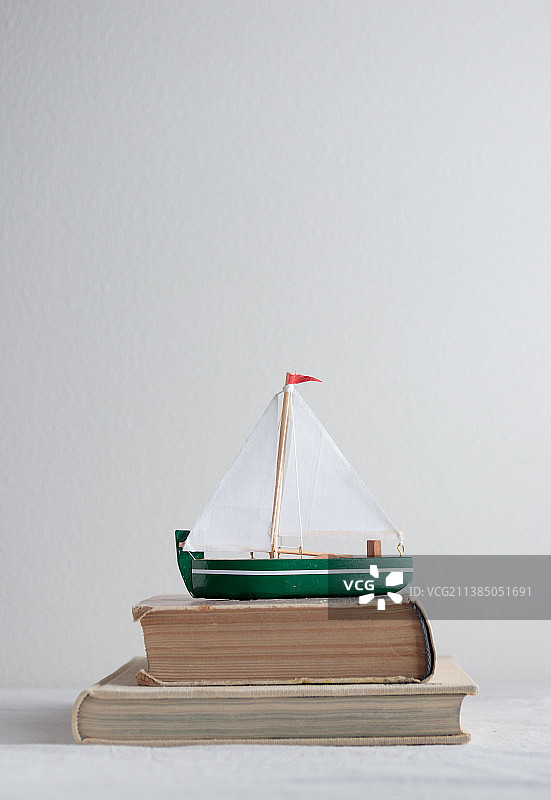 桌子上放着旧书的船模型图片素材