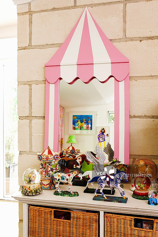 镜子前的玩具柜上的玩具，奇形怪状的框架靠在石墙上图片素材