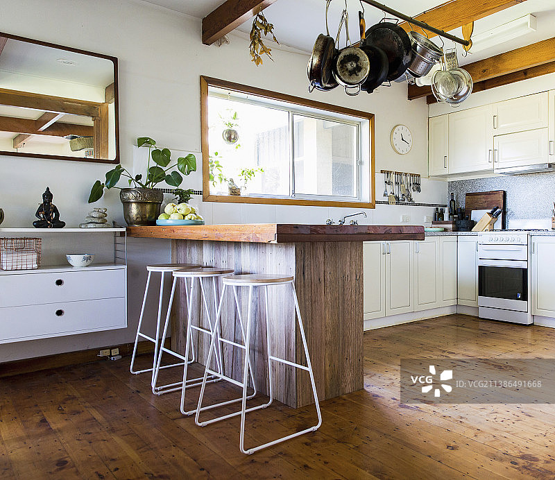 开放式厨房里的木制早餐吧台，配有精致的吧台凳图片素材