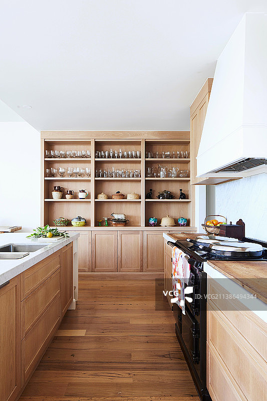厨房区域配有轻便的木制家具和宽敞的天花板高的嵌入式墙单元图片素材