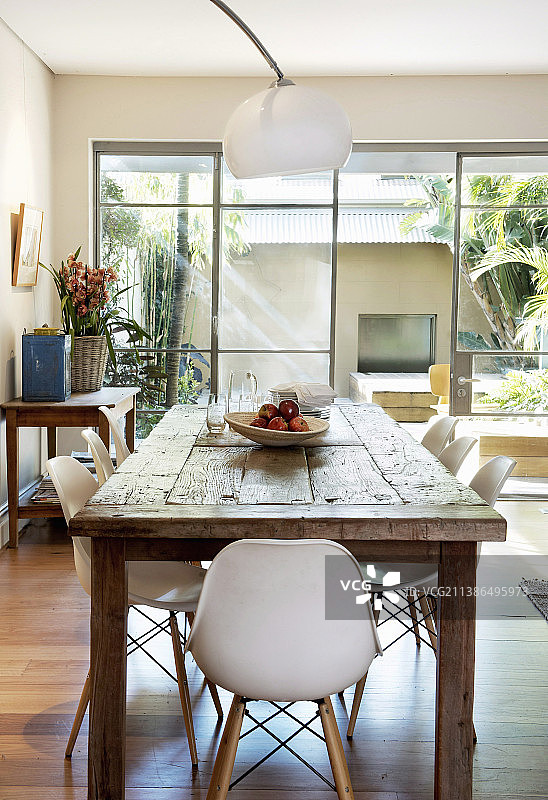 现代贝壳椅放在一张质朴的木桌前的窗前图片素材