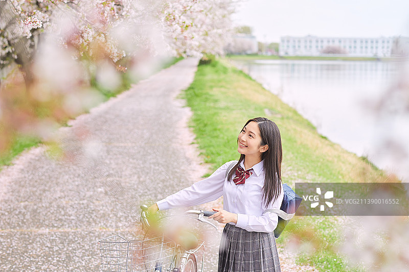 推自行车的日本女高中生图片素材