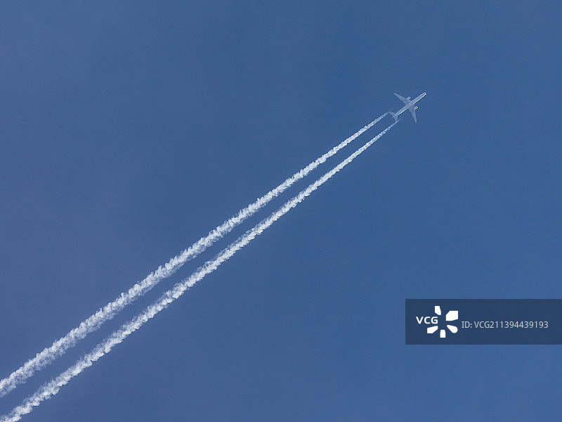 蓝天上的飞机带着凝结的痕迹图片素材