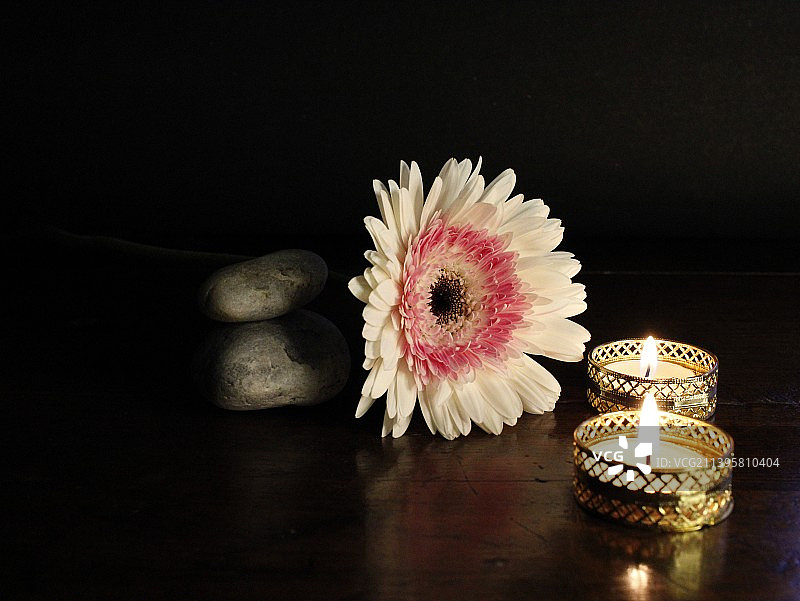 浪漫的水疗-按摩石头和鲜花在蜡烛光木制背景与副本空间图片素材