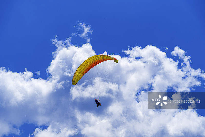 滑翔伞在蓝天白云间翱翔图片素材