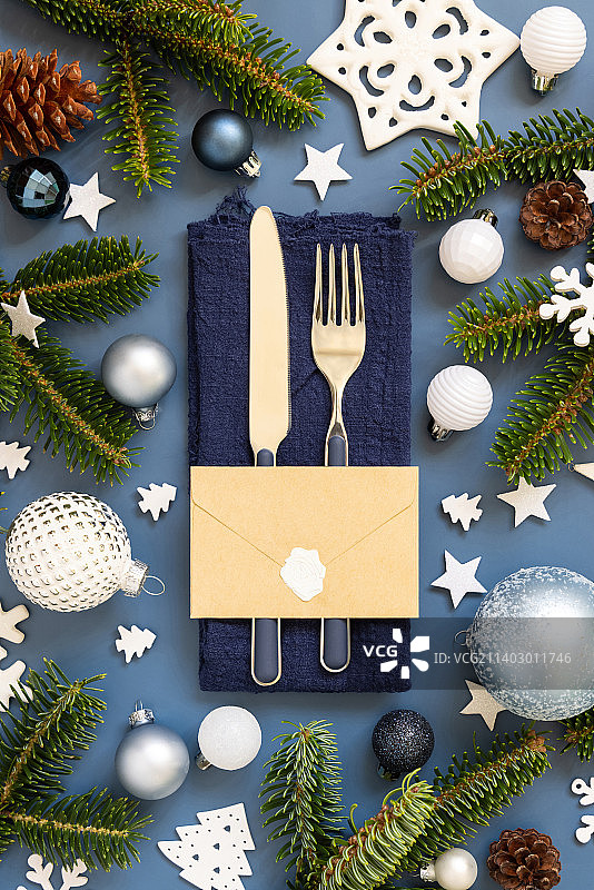 蓝色和白色的圣诞餐桌设置信封附近的装饰和杉树树枝顶视图图片素材