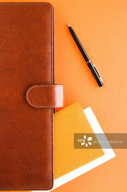 豪华商务棕色公文包放在写字台桌上，弗拉特莱图片素材