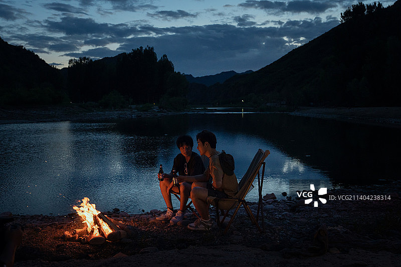 年轻人夜晚在野外篝火露营图片素材
