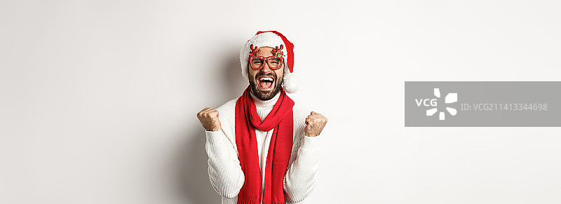 圣诞、新年和庆祝概念戴圣诞帽的兴奋男子图片素材