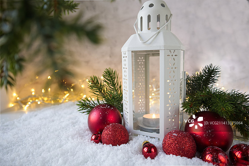 圣诞彩灯在雪的旁边衬着红色的有质感的小球图片素材