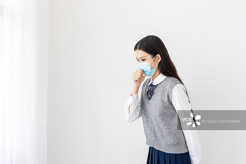 室内一名感冒咳嗽的亚洲女学生图片素材