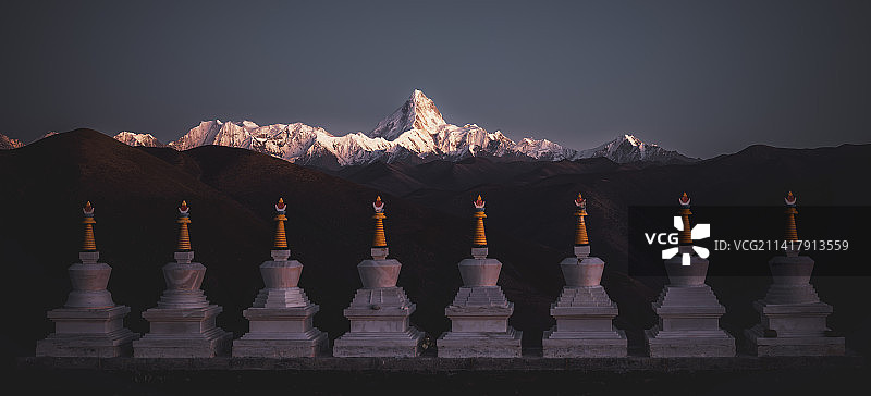 藏区白塔后面的贡嘎山夕照图片素材