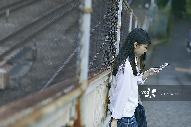 日本高中女生在操作手机图片素材