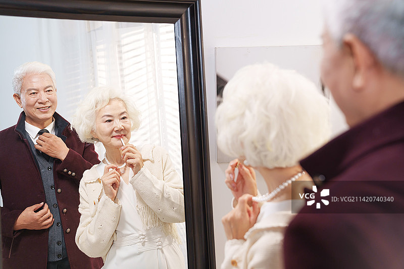 时尚的老年夫妇对着镜子穿衣打扮图片素材