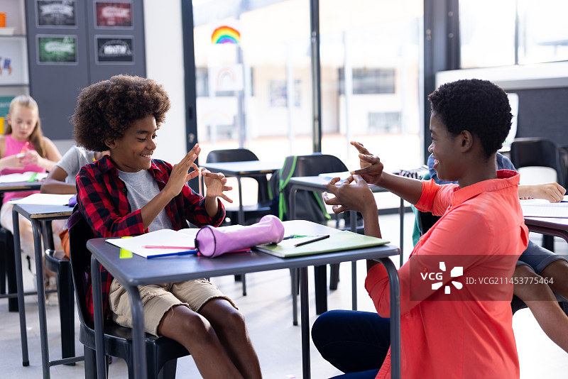 快乐的非裔美国女教师和在课堂上练习手语的男孩图片素材