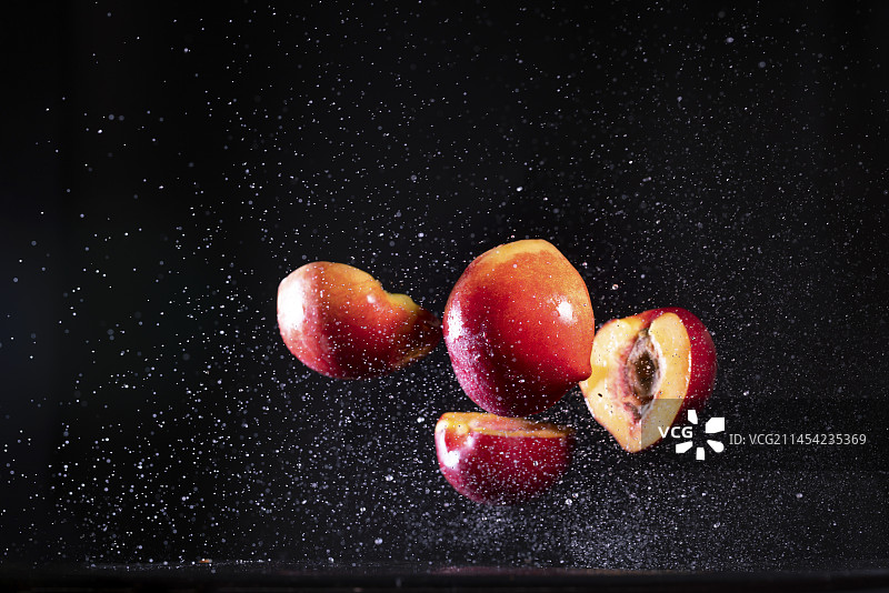 新鲜切开油桃在黑色背景上跳起来高速棚拍广告素材图片素材