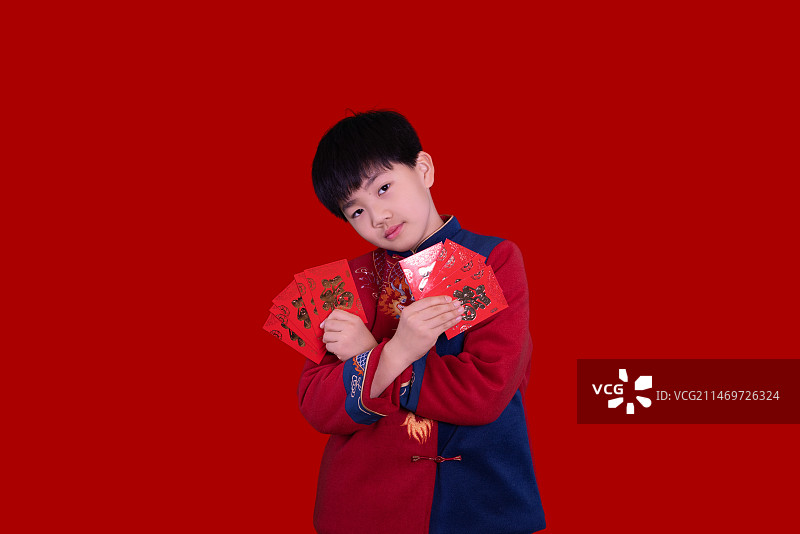 红色背景下中国小男孩春节恭贺新年拜年图片素材