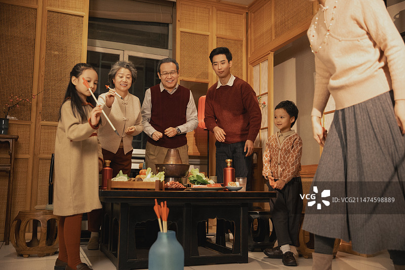 春节一家人吃年夜饭、玩投壶游戏图片素材