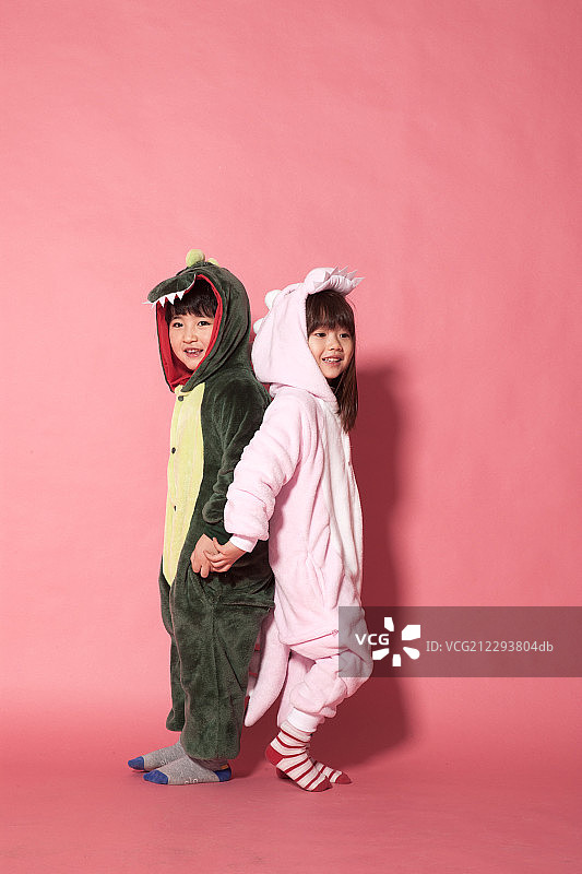 男孩和女孩穿着动物服装背靠背站着图片素材