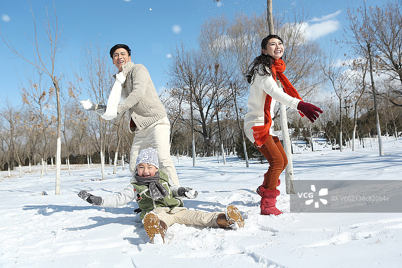 一家三口在雪地上打雪仗图片素材