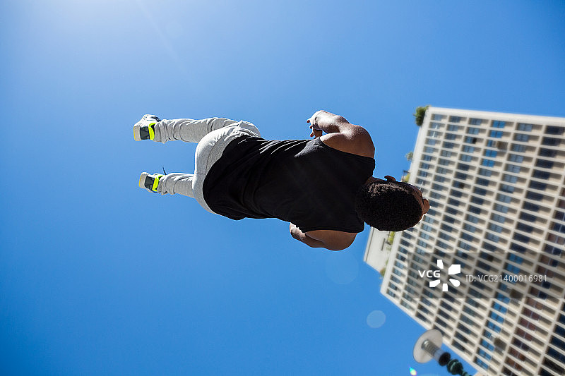 一个运动员在一个阳光明媚的日子里做后空翻图片素材